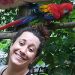 Ragazza sorridente davanti a pappagallo colorato su ramo - Chiara Grasso EticoScienza