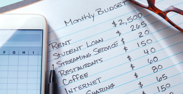 blocco notes che contiene l'elenco delle spese mensili - budgeting