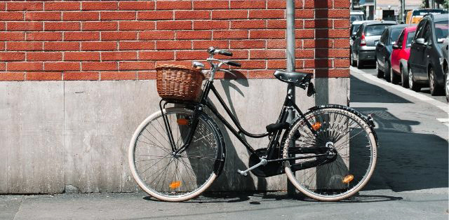 Bicicletta con cestino legata a un palo