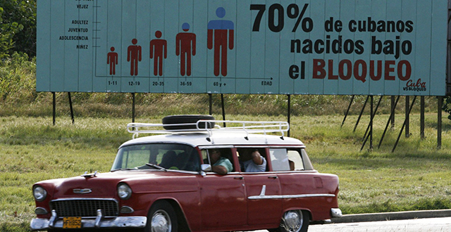 Macchina anni '60 davanti a cartellone pubblicitario - Cuba