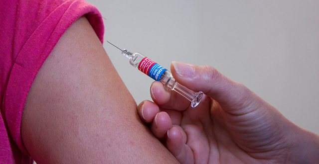 Mano con siringa vicino a braccio - vaccinazioni